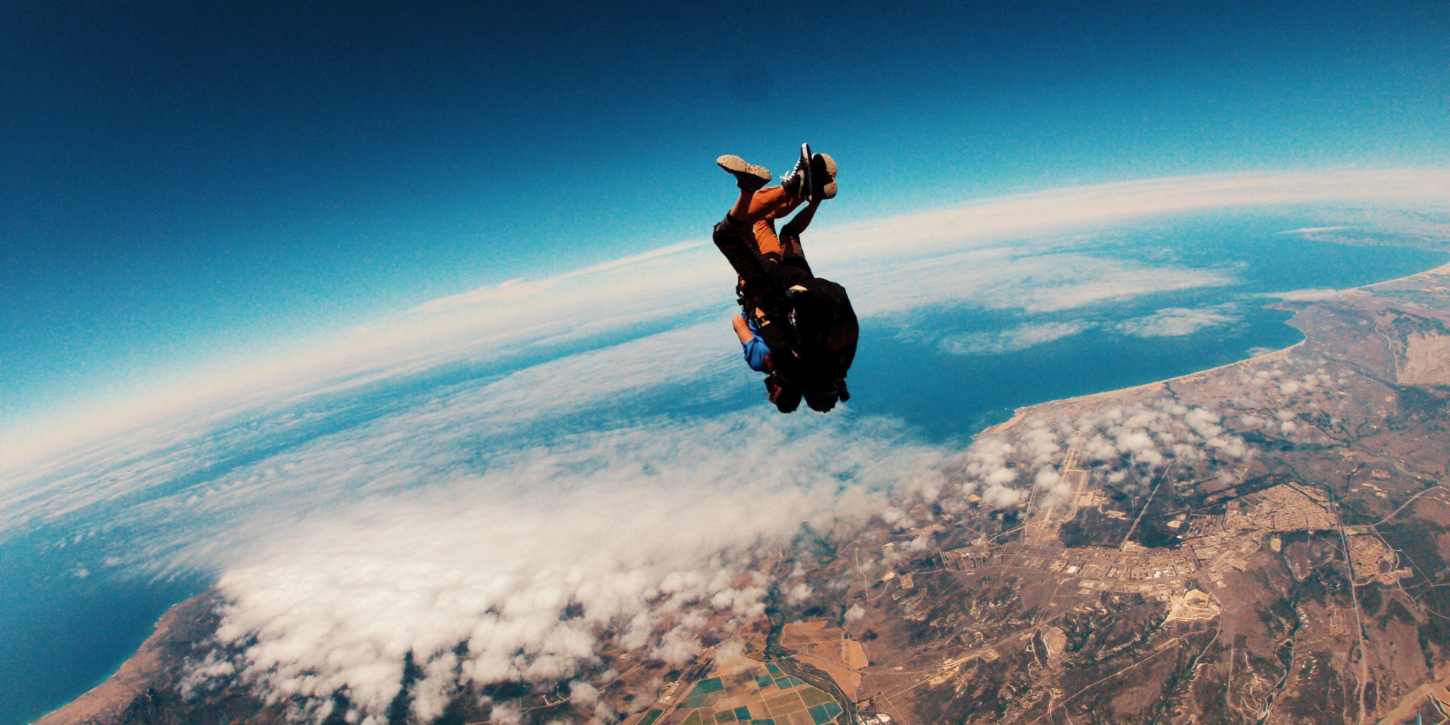 Skydiver is head down flying over a spectacular mountain scenery